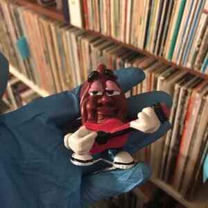 Guitar‑Playing Raisin Figurine - Red Guitar, Brown Body 1988 (California Raisin)